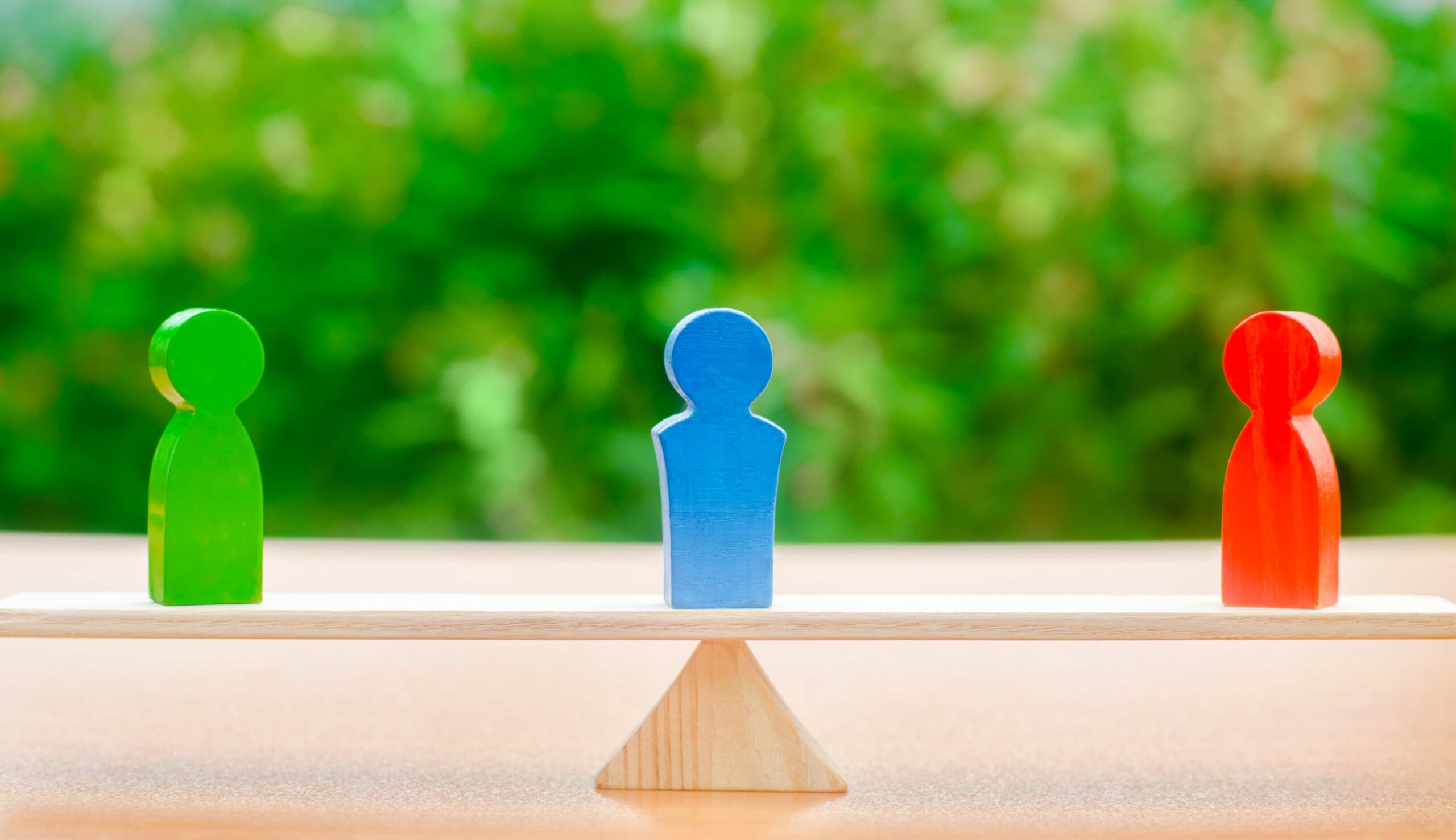 three wooden mediation figures on scale